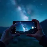 Ręce trzymają smartfon, na którym widać Drogę Mleczną. Dowiedz się, jak zrobić zdjęcie gwiazd telefonem.