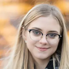 Uśmiechnięta blondynka w okularach. Idealna ogniskowa do portretu, by uchwycić jej spojrzenie i delikatny uśmiech.