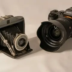 Stary aparat mieszkowy i nowoczesny Sony pokazują, jak działa aparat fotograficzny.
