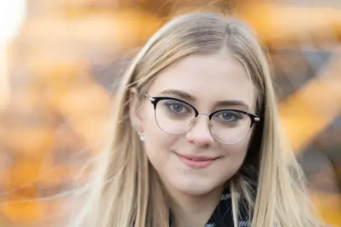 Uśmiechnięta blondynka w okularach. Idealna ogniskowa do portretu, by uchwycić jej spojrzenie i delikatny uśmiech.