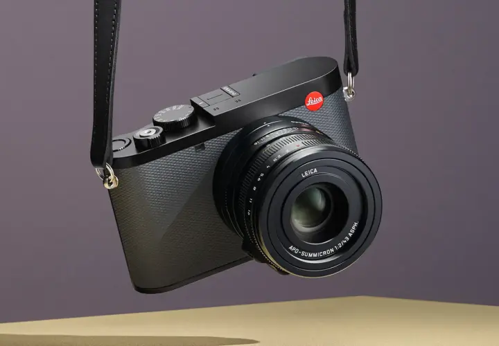 Elegancki aparat Leica z paskiem, gotowy do uchwycenia niezapomnianych chwil. Idealny do fotografii podróżniczej.