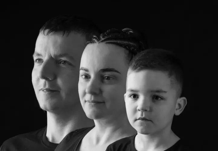 Trzy twarze w ujęciu monochromatycznym: mężczyzna, kobieta z warkoczami i chłopiec.