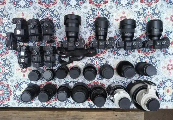 Kolekcja aparatów i obiektywów, w tym teleobiektyw. Zastanawiasz się, teleobiektyw co to? To obiektyw o długiej ogniskowej, idealny do fotografowania odległych obiektów.