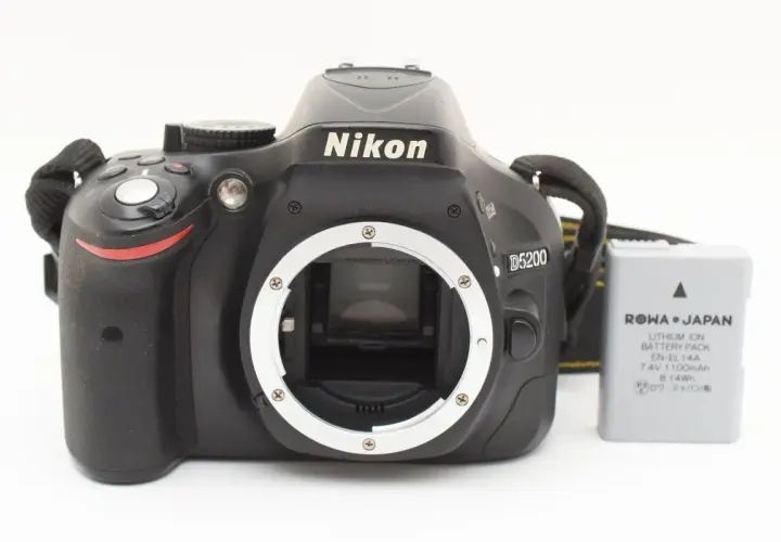 Aparat Nikon D5200 z obiektywem i baterią. Gotowy do uchwycenia niezapomnianych chwil.