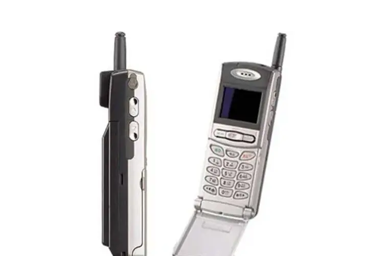 Dwa telefony komórkowe z lat 90. Jeden z nich to prawdopodobnie pierwszy telefon z aparatem, z charakterystyczną antenką i klapką.