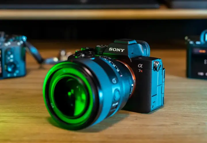 Sony a7r5 z zielonym obiektywem na drewnianym stole.