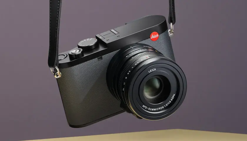 Elegancki aparat Leica z paskiem, gotowy do uchwycenia niezapomnianych chwil. Idealny do fotografii podróżniczej.