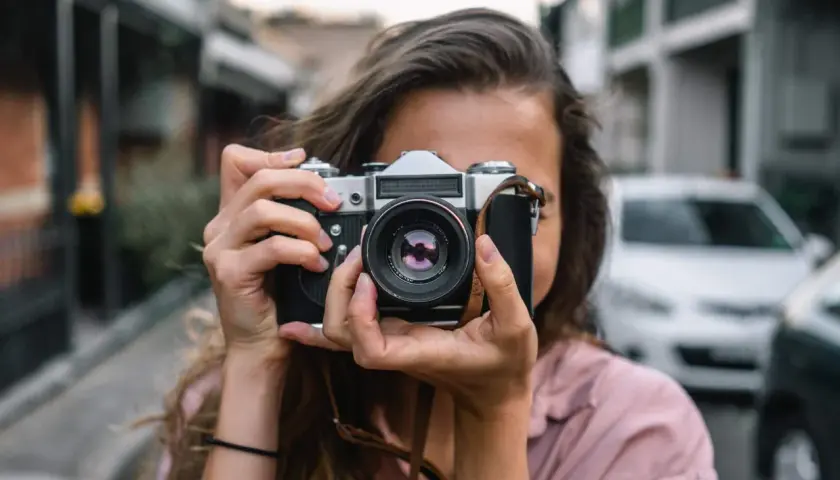 Dziewczyna z aparatem, idealna do kursu fotografii dla początkujących.