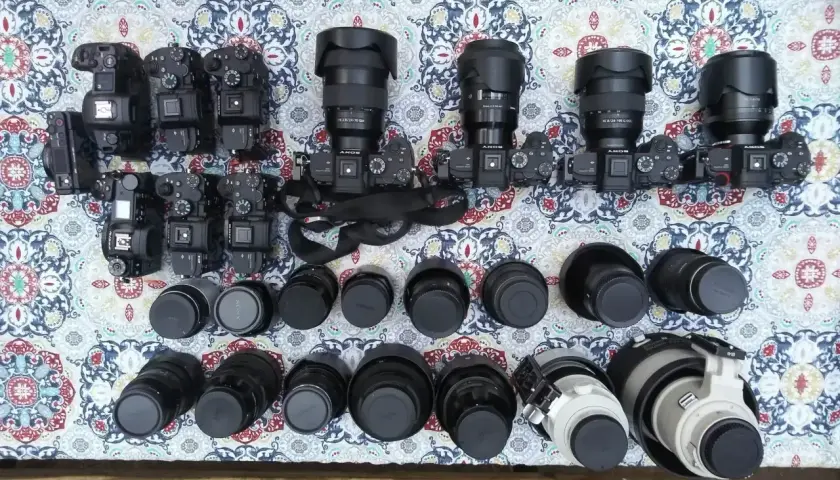 Kolekcja aparatów i obiektywów, w tym teleobiektyw. Zastanawiasz się, teleobiektyw co to? To obiektyw o długiej ogniskowej, idealny do fotografowania odległych obiektów.