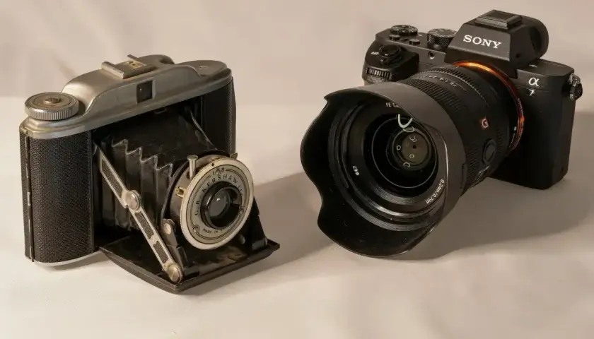 Stary aparat mieszkowy i nowoczesny Sony pokazują, jak działa aparat fotograficzny.