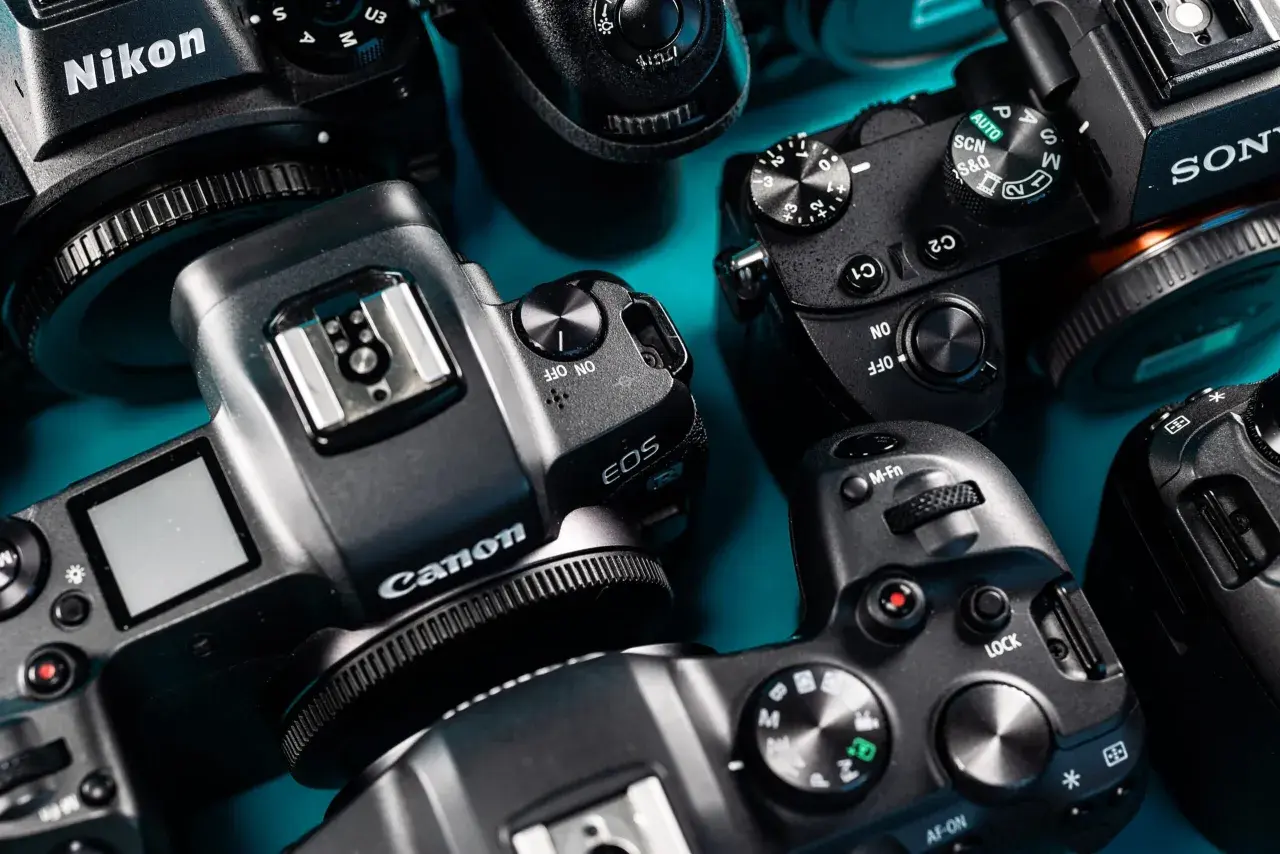 Kamera Nikon, Canon i Sony gotowe do sesji modowej. Zbliżenie na detale aparatów, przyciski i pokrętła.