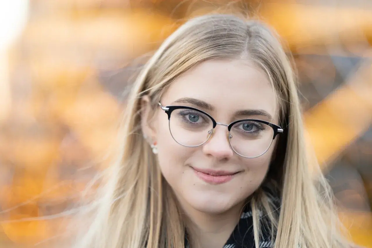 Uśmiechnięta blondynka w okularach. Idealna ogniskowa do portretu, by uchwycić jej spojrzenie i delikatny uśmiech.