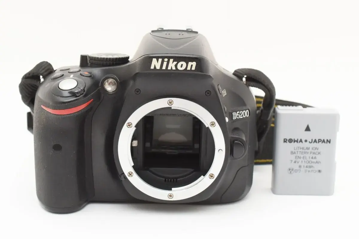 Aparat Nikon D5200 z obiektywem i baterią. Gotowy do uchwycenia niezapomnianych chwil.