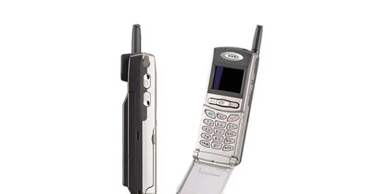 Dwa telefony komórkowe z lat 90. Jeden z nich to prawdopodobnie pierwszy telefon z aparatem, z charakterystyczną antenką i klapką.