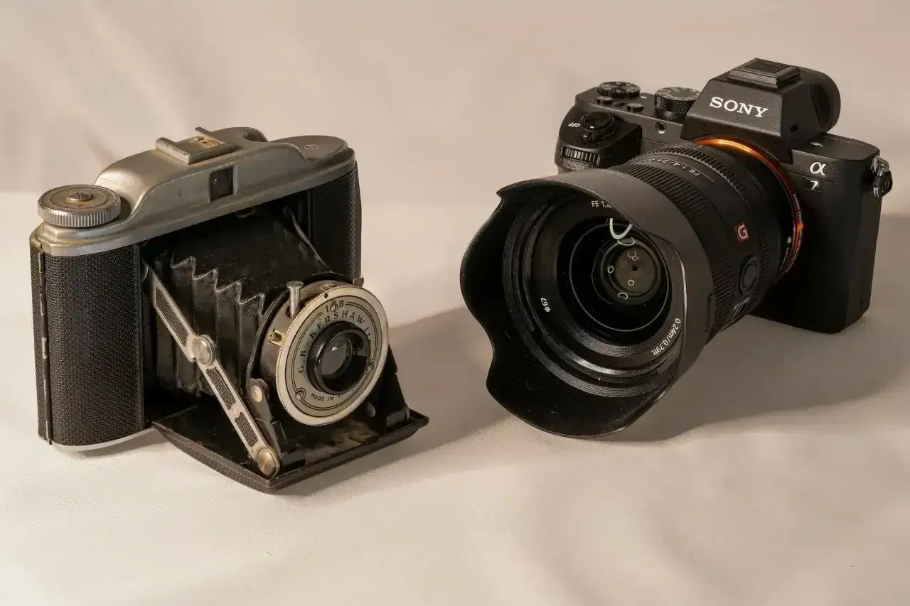 Stary aparat mieszkowy i nowoczesny Sony pokazują, jak działa aparat fotograficzny.