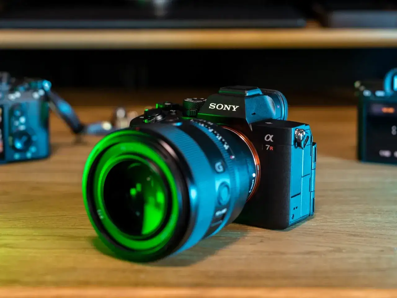 Sony a7r5 z zielonym obiektywem na drewnianym stole.