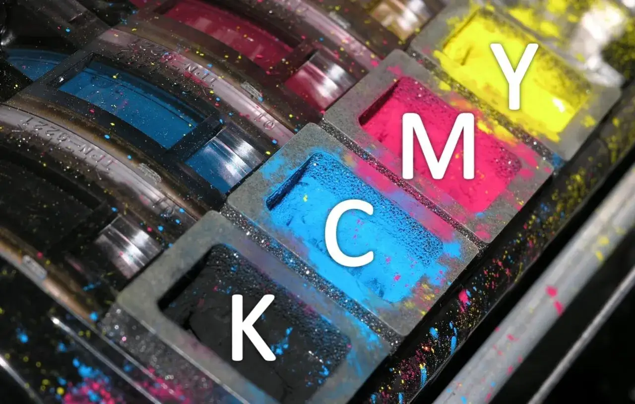 Zbliżenie na pojemniki z tuszami: cyjan (C), magenta (M), żółty (Y) i czarny (K). To są podstawowe kolory druku.