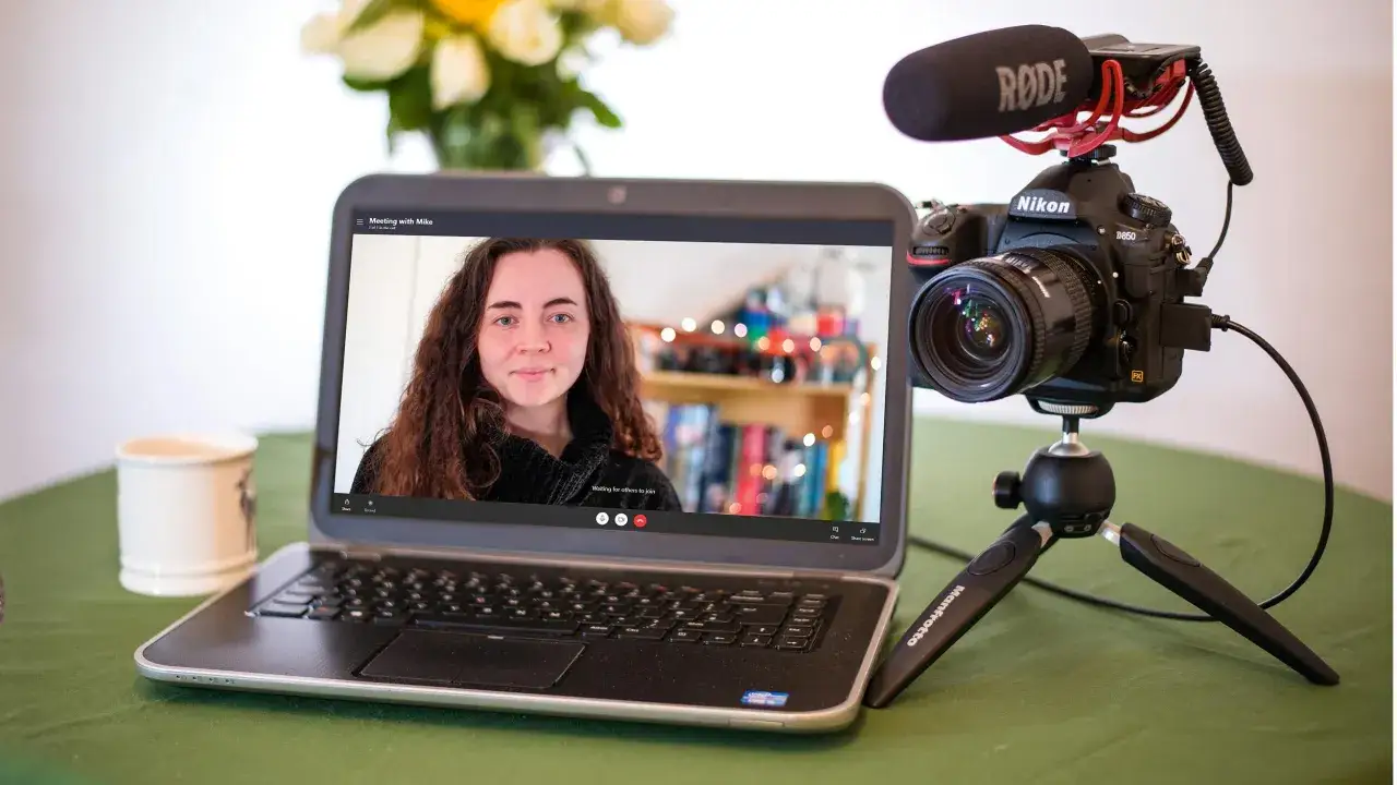 Nikon D850 z mikrofonem Rode jako kamera internetowa, podłączony do laptopa z uruchomionym programem Nikon Webcam Utility.