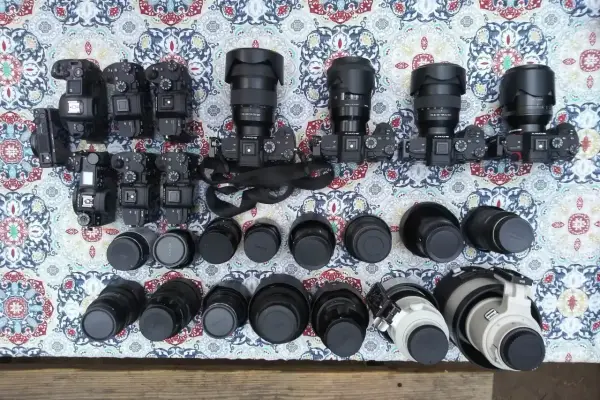 Kolekcja aparatów i obiektywów, w tym teleobiektyw. Zastanawiasz się, teleobiektyw co to? To obiektyw o długiej ogniskowej, idealny do fotografowania odległych obiektów.